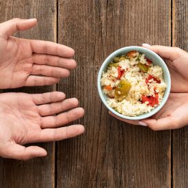 Hand gibt Schüssel Essen bedürftige Person © IMAGO / imagebroker